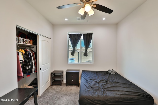 carpeted bedroom with ceiling fan and a closet