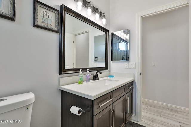 bathroom featuring hardwood / wood-style floors, vanity, and toilet