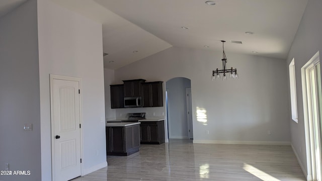 kitchen with appliances with stainless steel finishes, lofted ceiling, and a notable chandelier