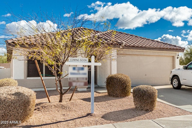 view of front of home featuring an attached garage, stucco siding, concrete driveway, and a tiled roof