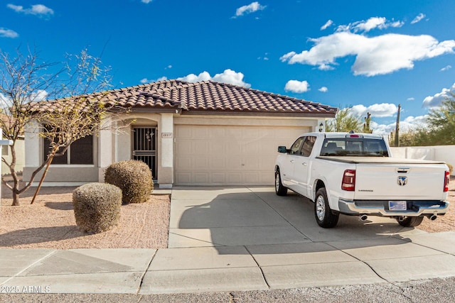 mediterranean / spanish-style home with an attached garage, a tile roof, concrete driveway, and stucco siding