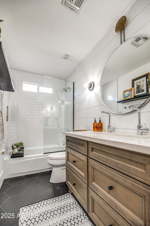 full bathroom with toilet, tile patterned floors, shower / bath combination with glass door, and vanity