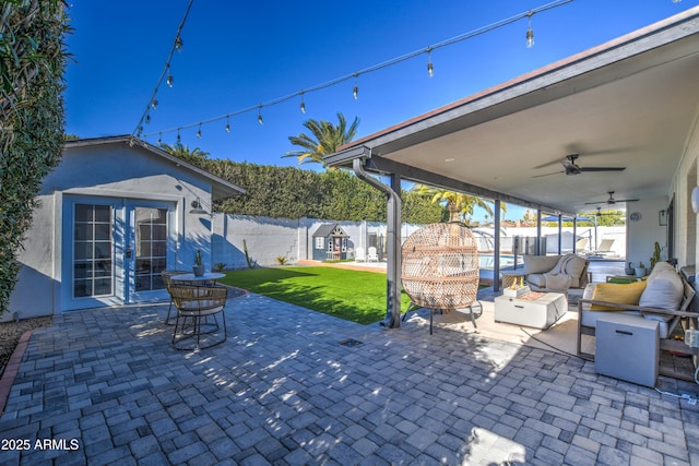 view of patio with french doors, ceiling fan, outdoor lounge area, and an outbuilding