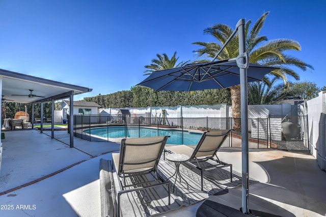 view of swimming pool with a storage shed, a patio area, and ceiling fan