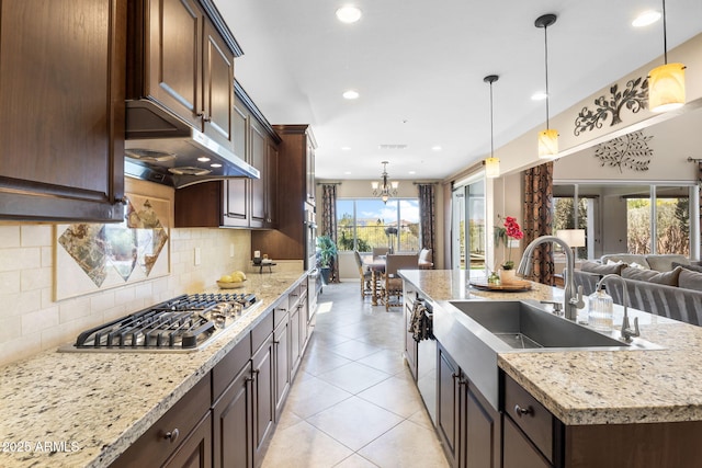 31156 N 137th Ln, Peoria, AZ 85383 - kitchen featuring under cabinet range hood, a sink, stainless steel gas cooktop, open floor plan, and dark brown cabinetry