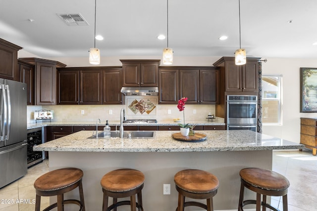 31156 N 137th Ln, Peoria, AZ 85383 - kitchen featuring stainless steel appliances, beverage cooler, a sink, decorative backsplash, and a breakfast bar area