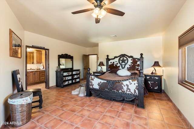 tiled bedroom with ensuite bath and ceiling fan