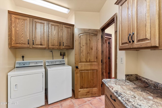 clothes washing area featuring cabinets, light tile patterned floors, and washing machine and dryer