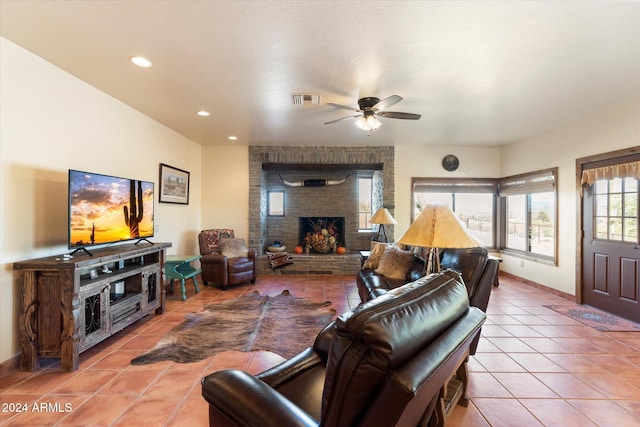 tiled living room featuring ceiling fan and a fireplace