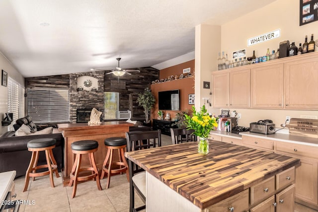 kitchen featuring open floor plan, butcher block counters, and light brown cabinets