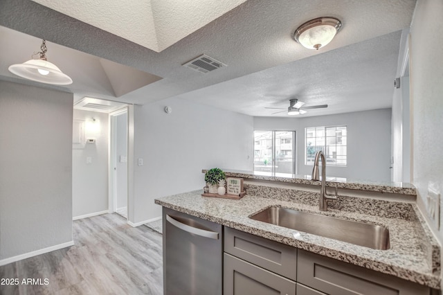 kitchen featuring sink, a textured ceiling, dishwasher, light stone countertops, and light hardwood / wood-style floors