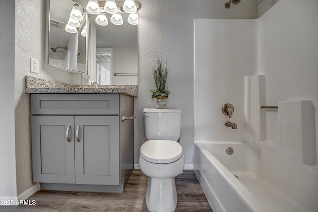 full bathroom with hardwood / wood-style flooring, vanity, shower / tub combination, and toilet