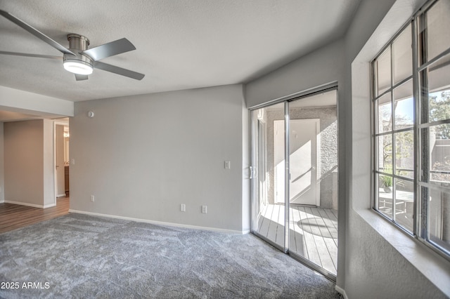 carpeted spare room with ceiling fan and a textured ceiling