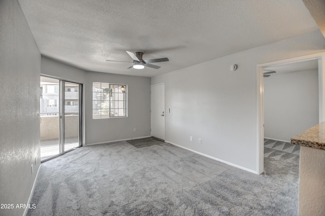 unfurnished room with ceiling fan, carpet floors, and a textured ceiling