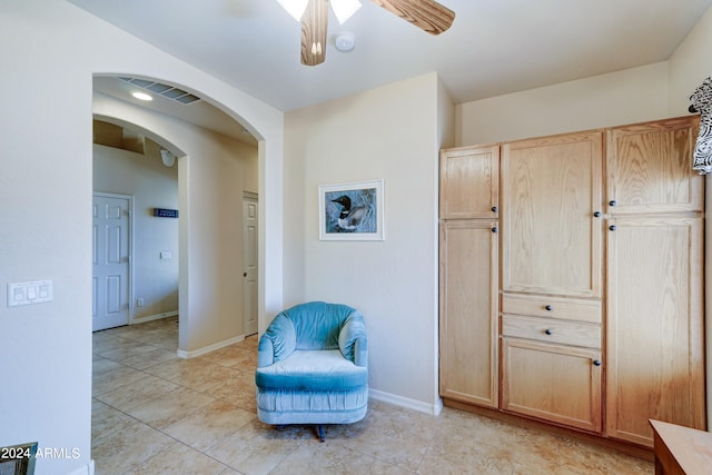 living area with ceiling fan and light tile patterned floors