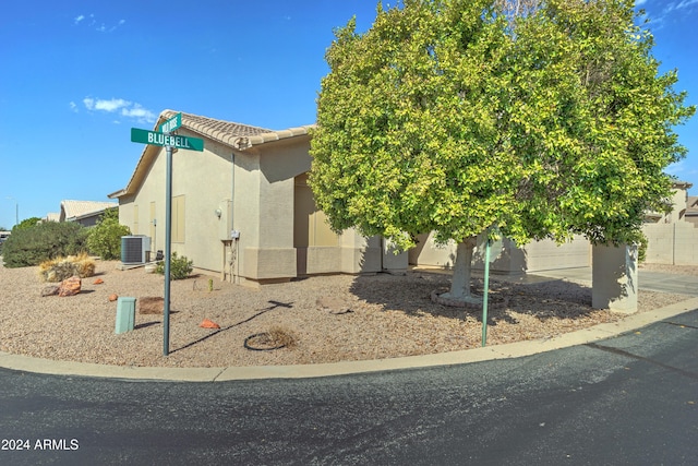 view of side of property featuring central AC unit and a garage