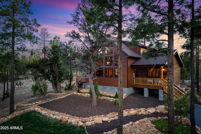 3334 Sawmill Ridge Loop, Heber, AZ 85928 - back of house at dusk featuring stairway, covered porch, and a shingled roof