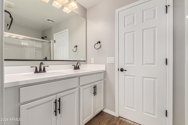 bathroom with hardwood / wood-style flooring, vanity, and an enclosed shower