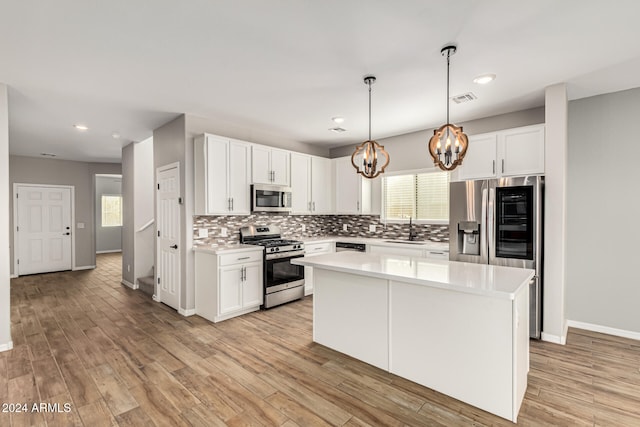 kitchen featuring white cabinets, a center island, light wood-type flooring, and appliances with stainless steel finishes