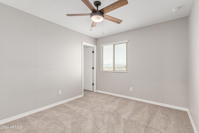 spare room featuring light colored carpet and ceiling fan