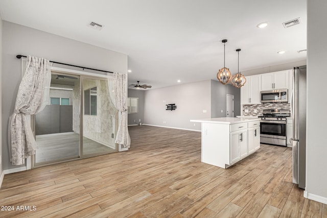 kitchen featuring white cabinetry, light hardwood / wood-style flooring, a kitchen island, ceiling fan with notable chandelier, and appliances with stainless steel finishes