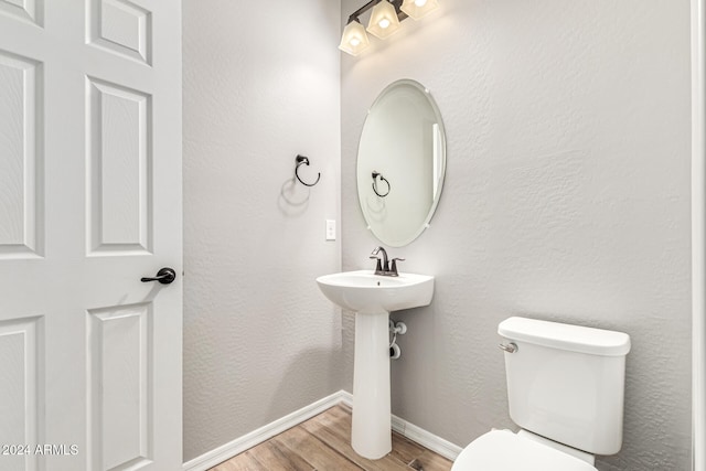 bathroom with toilet and hardwood / wood-style flooring