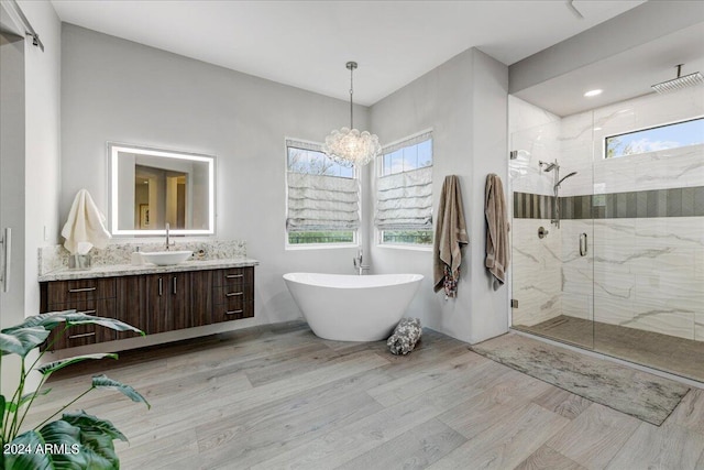 bathroom featuring large vanity, hardwood / wood-style flooring, a chandelier, and independent shower and bath