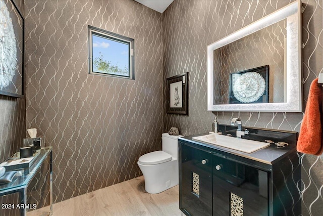 bathroom with hardwood / wood-style flooring, vanity, and toilet