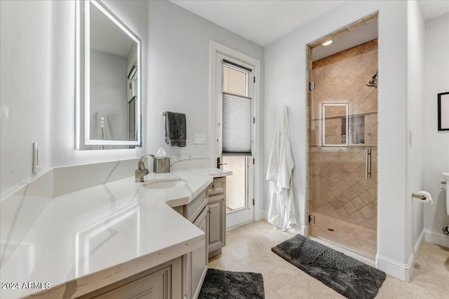 bathroom with a tile shower, plenty of natural light, tile floors, and vanity with extensive cabinet space