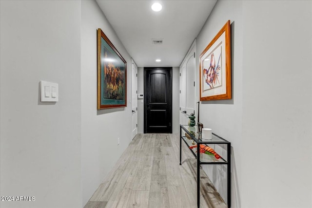 corridor with light hardwood / wood-style floors