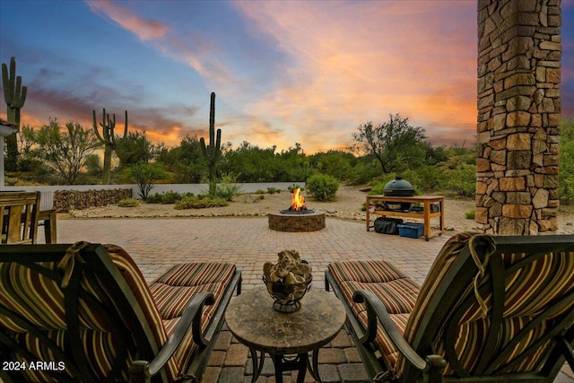 patio terrace at dusk featuring an outdoor fire pit