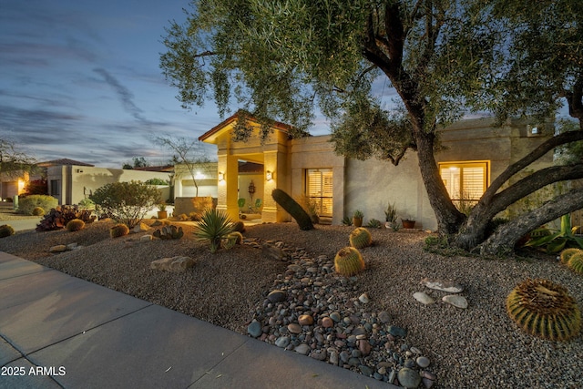 view of front of home with a garage and stucco siding