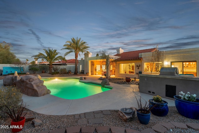 view of pool with a patio area, a fenced in pool, fence, and exterior kitchen