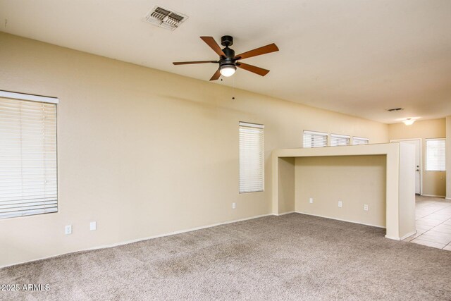 spare room with visible vents, light colored carpet, and a ceiling fan