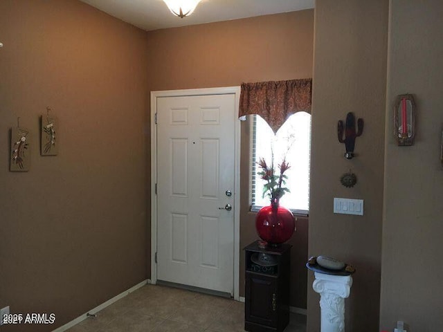 foyer with light tile patterned flooring and baseboards