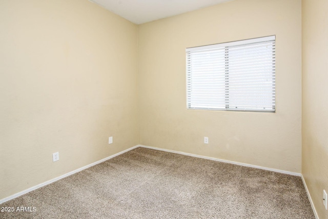 spare room featuring baseboards and carpet floors