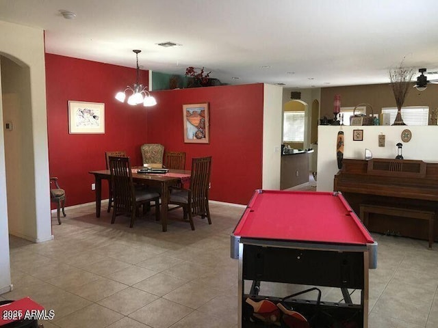 rec room featuring arched walkways, a notable chandelier, light tile patterned floors, visible vents, and baseboards