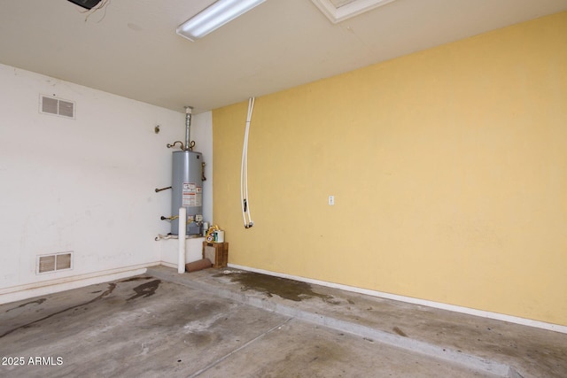 garage featuring visible vents, gas water heater, and baseboards