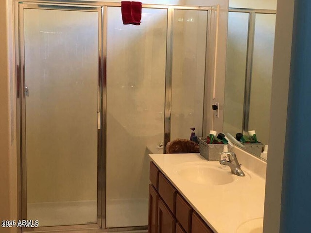 bathroom featuring a sink, a stall shower, and double vanity