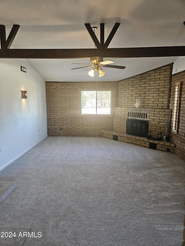 unfurnished living room with lofted ceiling, carpet flooring, ceiling fan, a fireplace, and brick wall