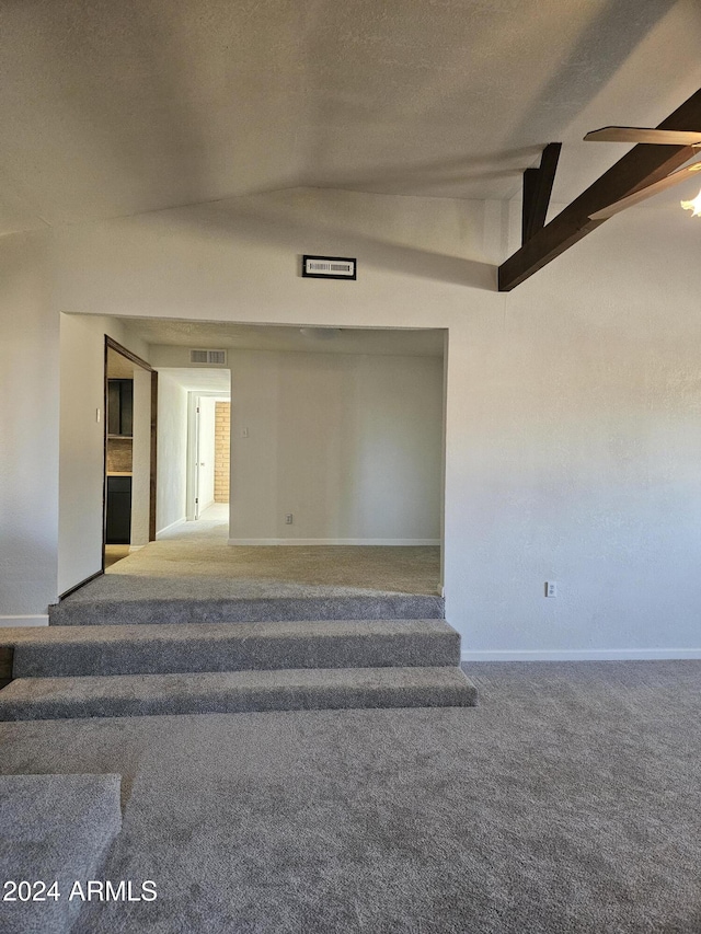 stairs featuring carpet flooring, a textured ceiling, and vaulted ceiling