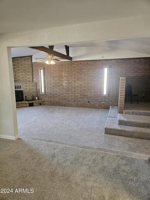 interior space featuring carpet flooring, lofted ceiling with beams, and brick wall