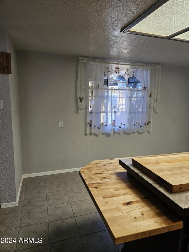 interior space featuring dark tile patterned floors and a textured ceiling