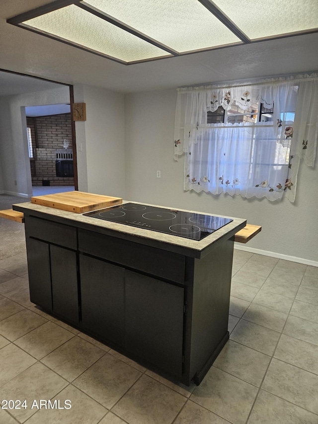 kitchen featuring black electric stovetop and light tile patterned flooring