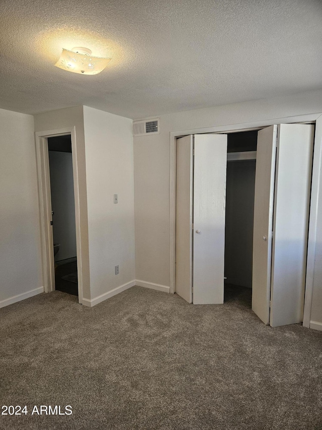 unfurnished bedroom with carpet floors, a textured ceiling, and a closet