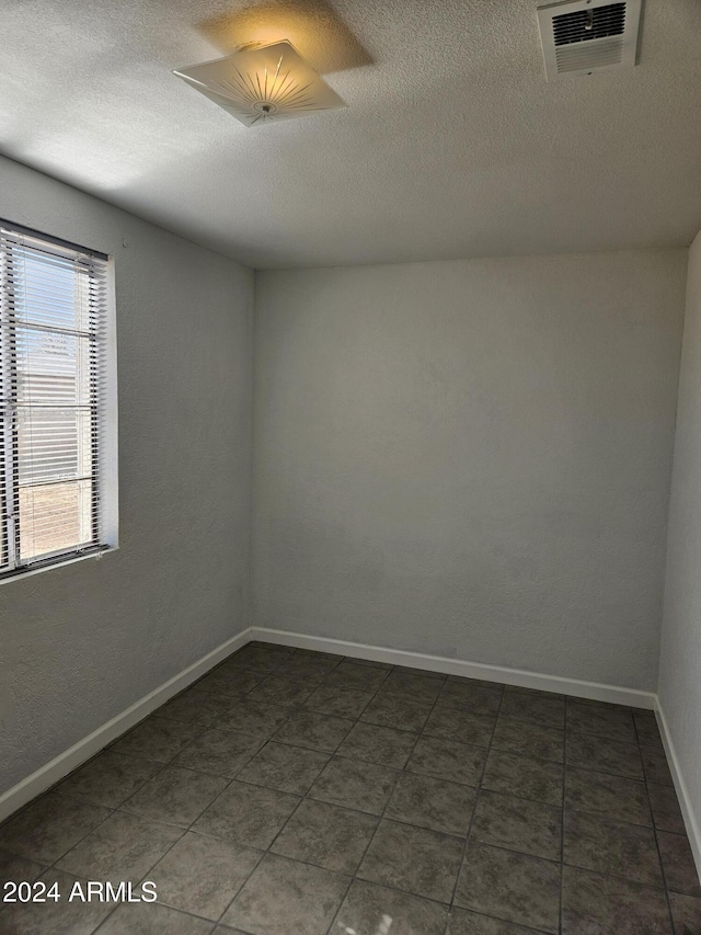 spare room with a textured ceiling