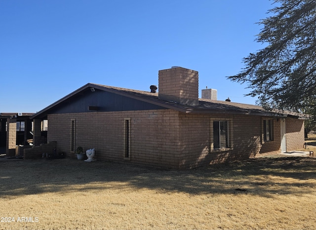 back of house with cooling unit and a lawn