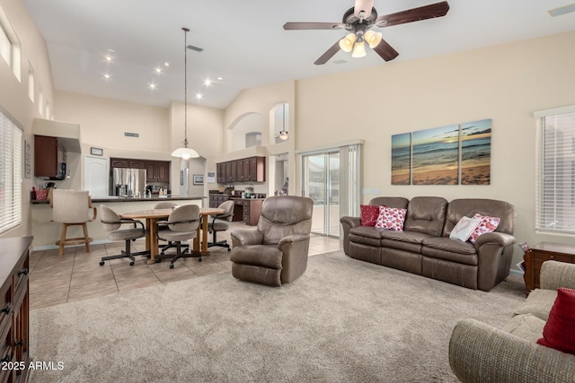 tiled living room featuring ceiling fan and high vaulted ceiling