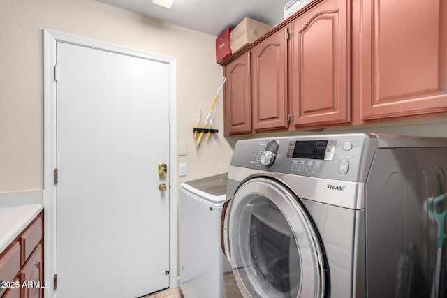 laundry room with washing machine and dryer and cabinets