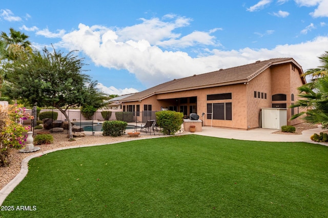 back of house with a fenced in pool, an outdoor kitchen, a yard, and a patio area